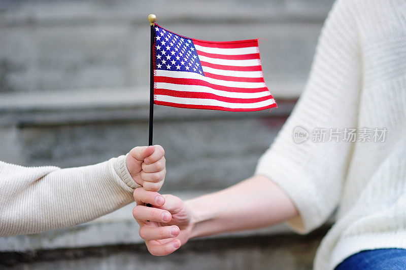 年轻妇女和小孩举着美国国旗