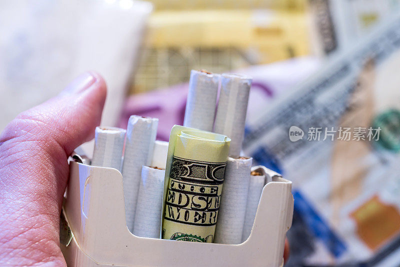 美元钞票和香烟堆。