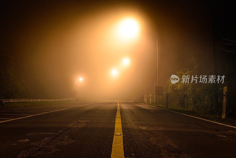 薄雾中有夜灯的乡间小路。