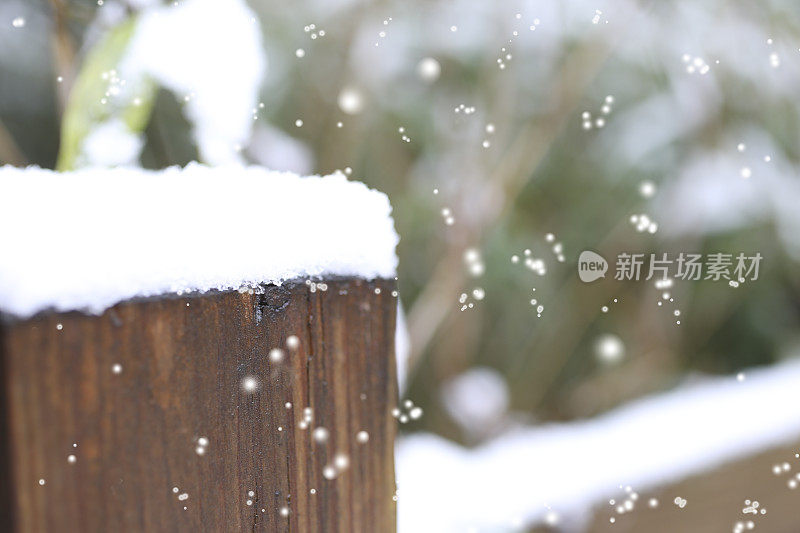 冬天的雪落在户外景观与篱笆柱。