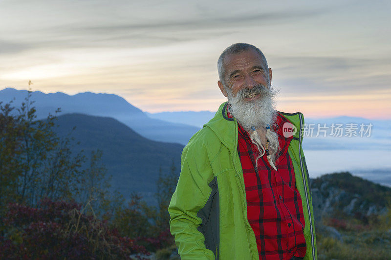 快乐的老年人远足在秋天的黎明在朱利安阿尔卑斯山，斯洛文尼亚，欧洲