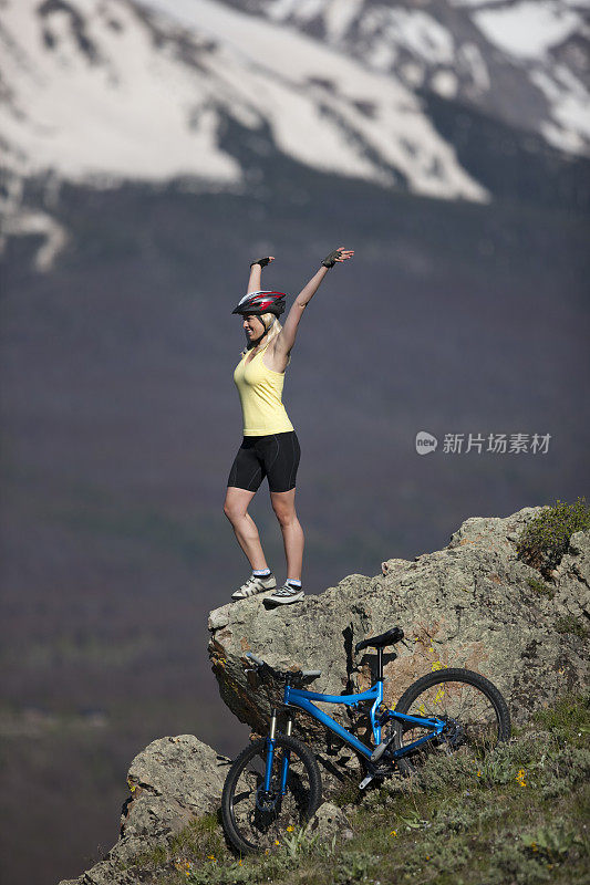 女性庆祝骑自行车爬到山顶