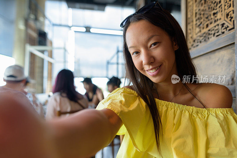 年轻美丽的多民族旅游女人的肖像放松在泰国曼谷的餐厅