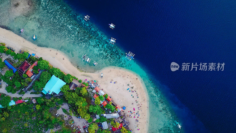 在菲律宾宿务岛Oslob附近的Sumilon岛海滩上，游客在美丽清澈的海水中游泳的沙滩鸟瞰图。-增强颜色处理。