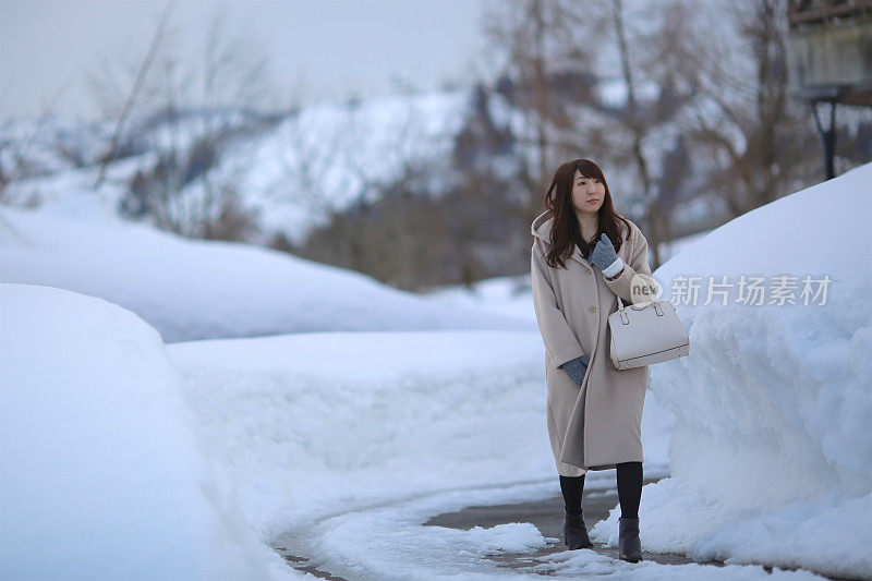 女人走在白雪覆盖的小路上