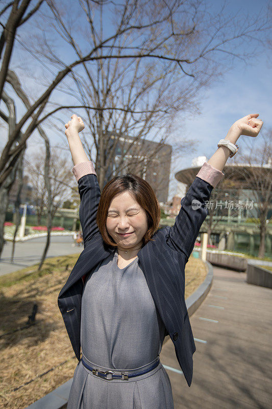 年轻的女商人早上在外面伸懒腰