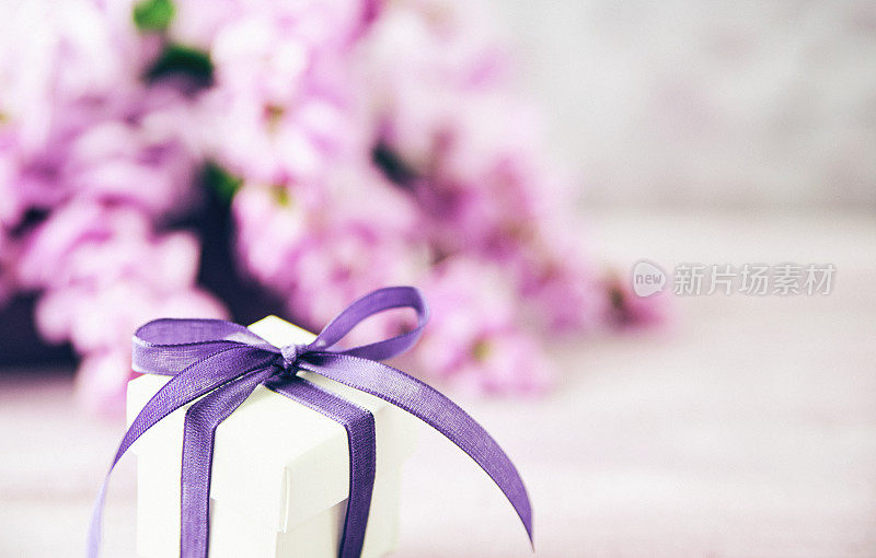 紫丝带和紫藤花束的礼盒