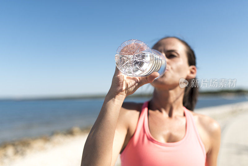 喝瓶子里水的女人