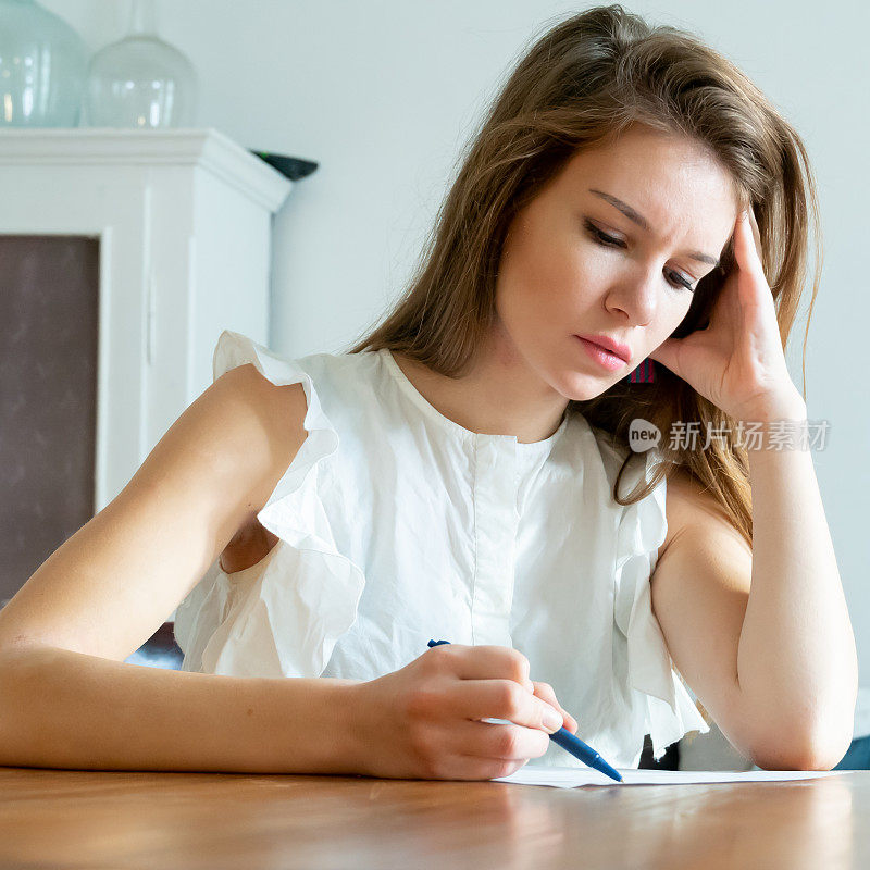 年轻女子在纸上写字