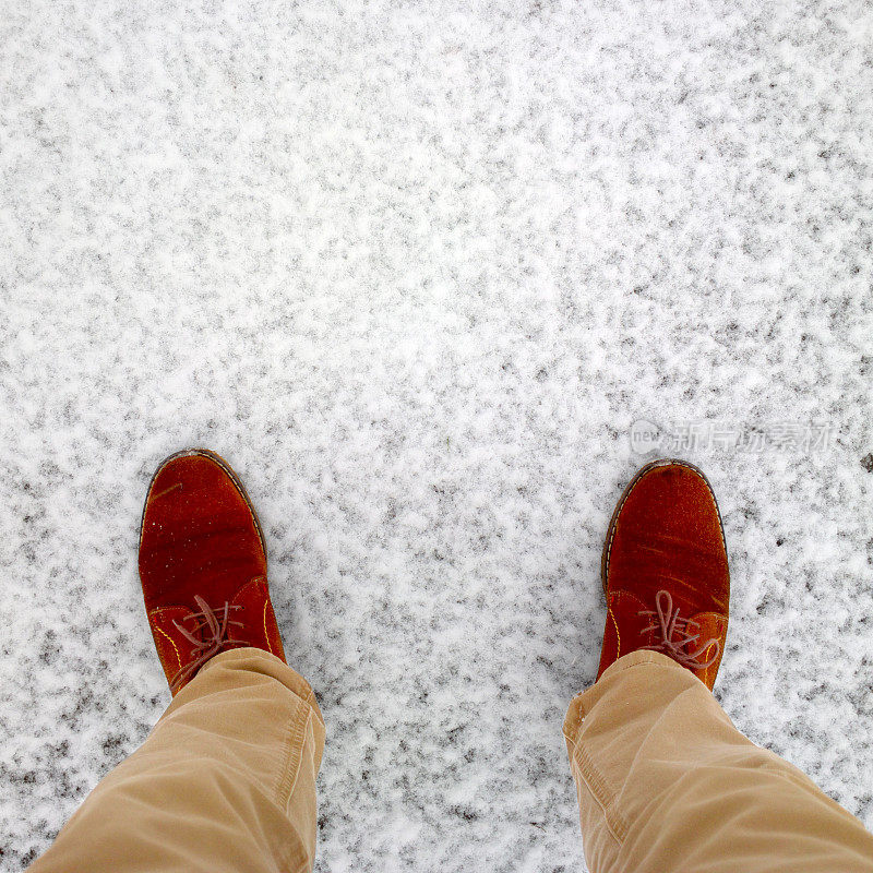 英尺的雪。棕色的鞋子踩在雪地上。