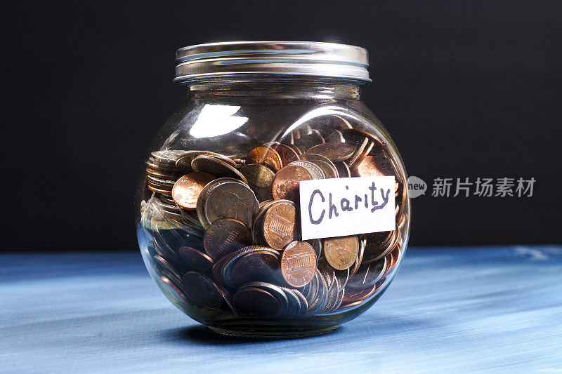 玻璃罐子装满了标有慈善的硬币