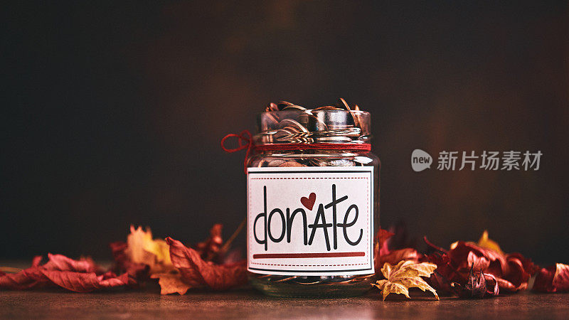 秋叶环绕的捐赠罐。