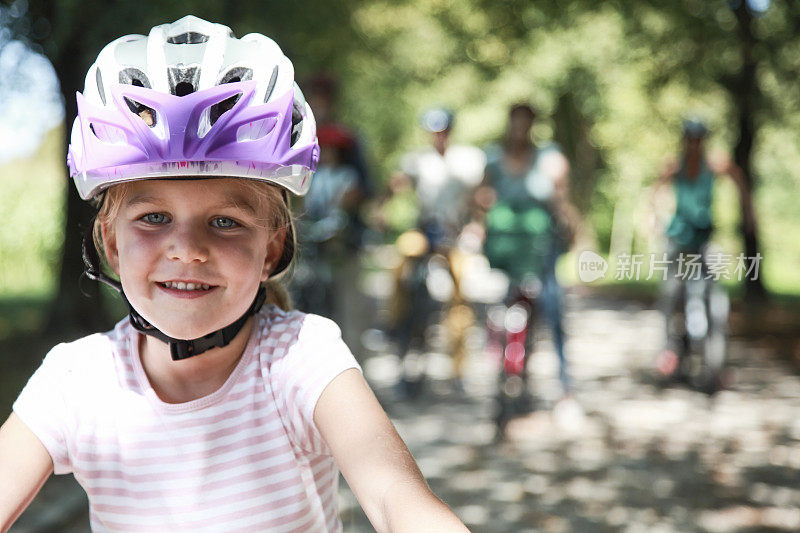 小女孩肖像与她的家人在自行车在后面-家庭自行车旅行
