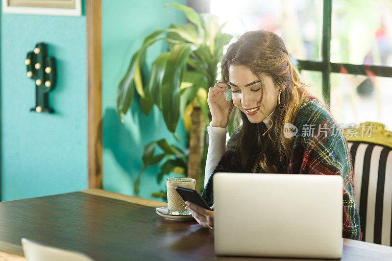 一个年轻女子在咖啡店发短信