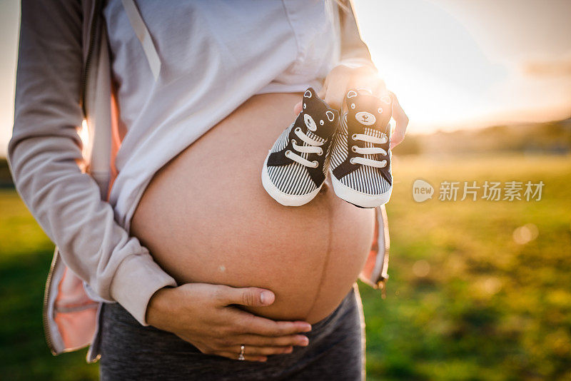 特写孕妇的婴儿鞋。