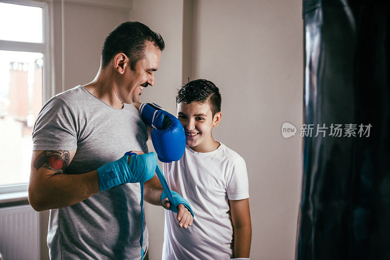 年轻的男孩拳击手准备与教练拳击