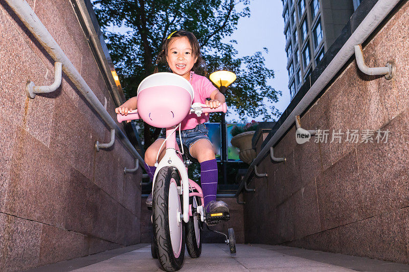 一个小女孩在学骑自行车