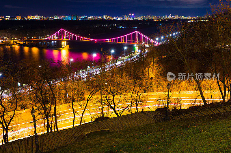 夜景，基辅，乌克兰。乌克兰基辅第聂伯罗河上的人行桥上的夜间照明。