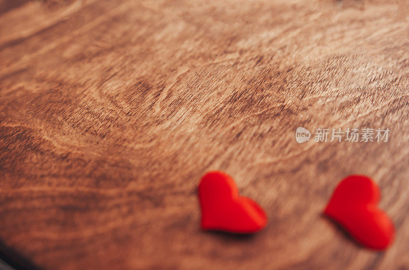 木制纹理背景上的两颗红心。两颗红心在破旧的木头背景上