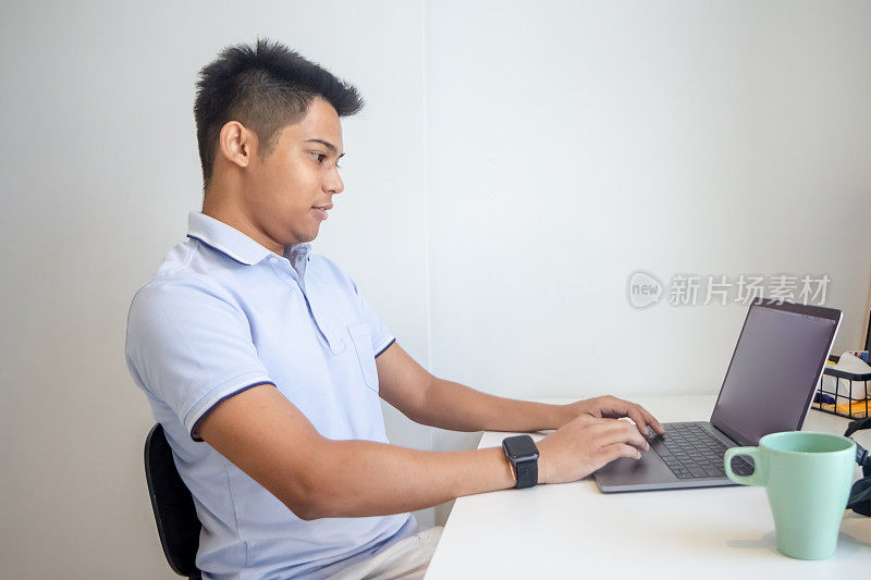 一个年轻的商人使用他的笔记本电脑工作
