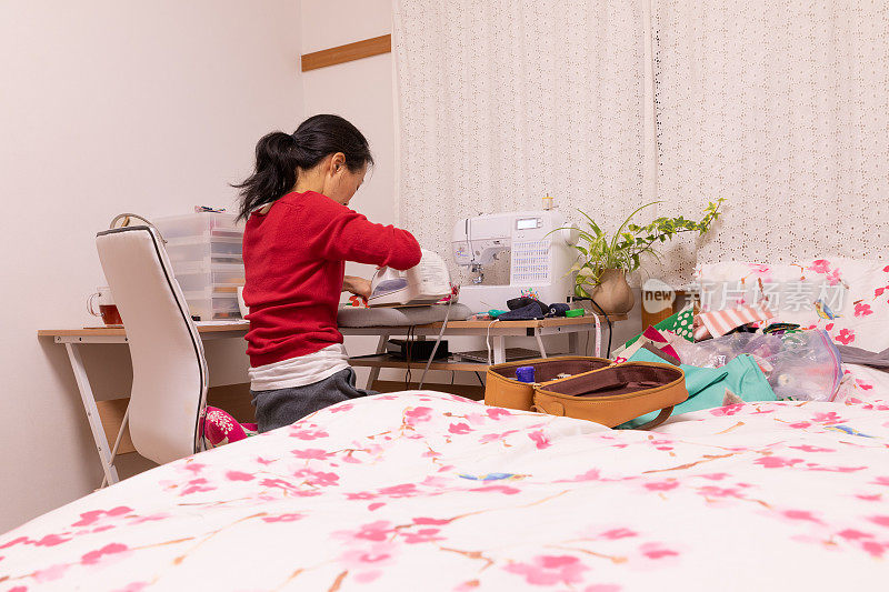 一名日本妇女在家里制作面具