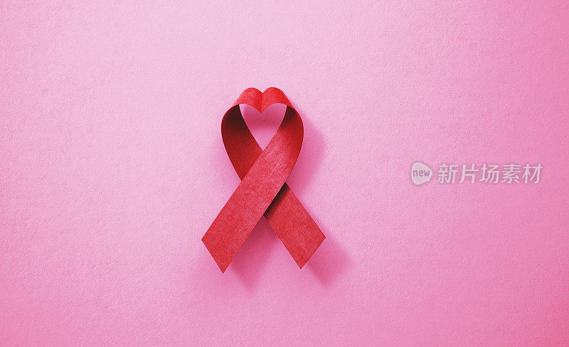 粉色背景上的艾滋病意识丝带