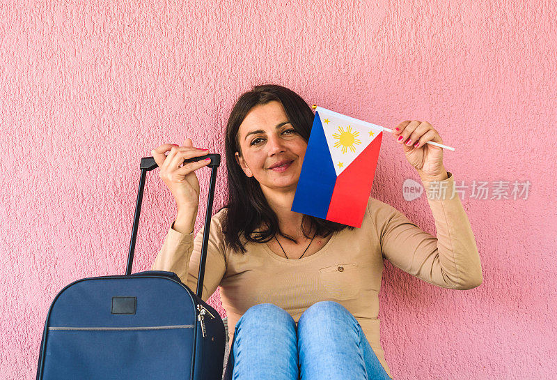 拿着旅行袋和菲律宾国旗的女人