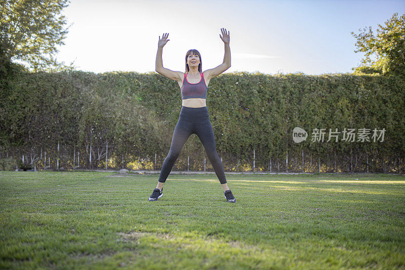 一名女子在大自然中练习开合跳