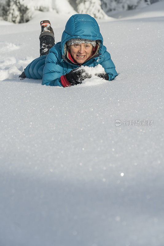 在冬天的森林里，成熟的女人穿着皮大衣躺在雪地里
