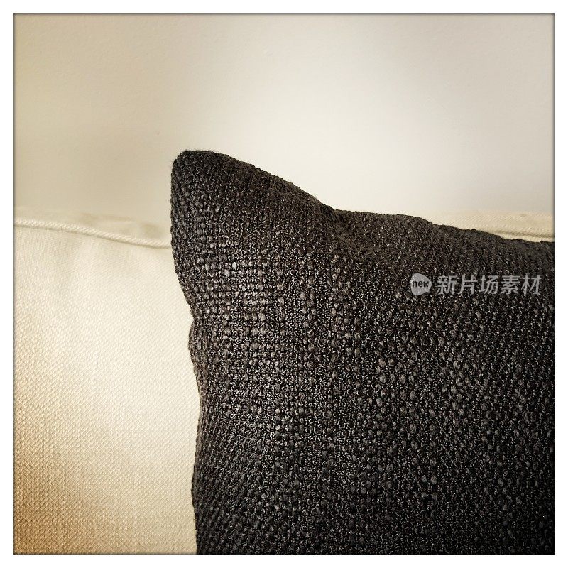 米色沙发上的黑色枕头