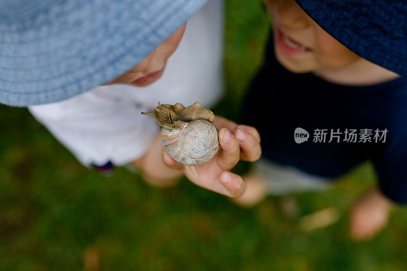 戴太阳帽的小孩羡慕蜗牛