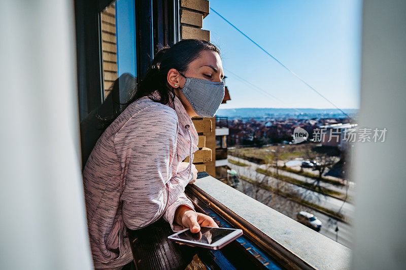 被隔离的女人从窗户往外看