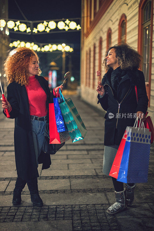 年轻漂亮的女人在圣诞节一起购物时玩得很开心