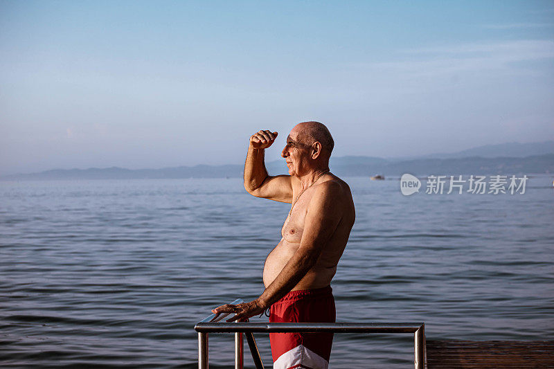 从木栈桥上，年长的男游客欣赏着海景