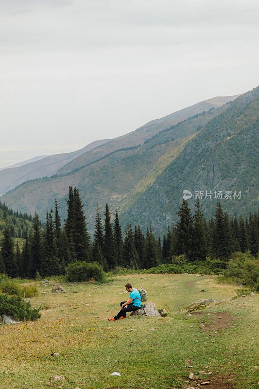 一名背包客在夏天的中亚山区徒步旅行