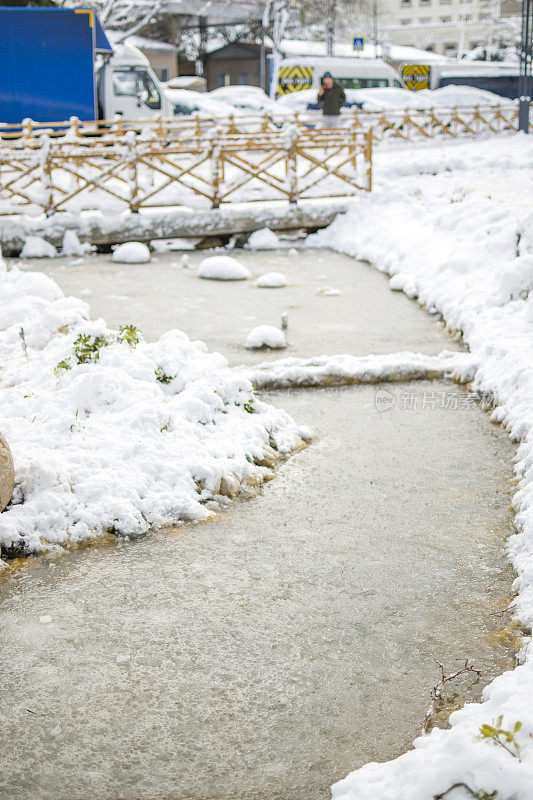 美丽的冬季公园，结冰的水覆盖着雪