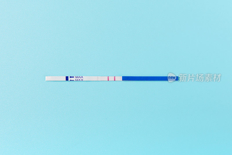 真实阳性妊娠测试。孤立在蓝色背景。