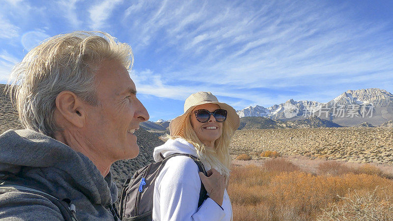 一对徒步旅行的夫妇沿着小路穿过干旱的沙漠