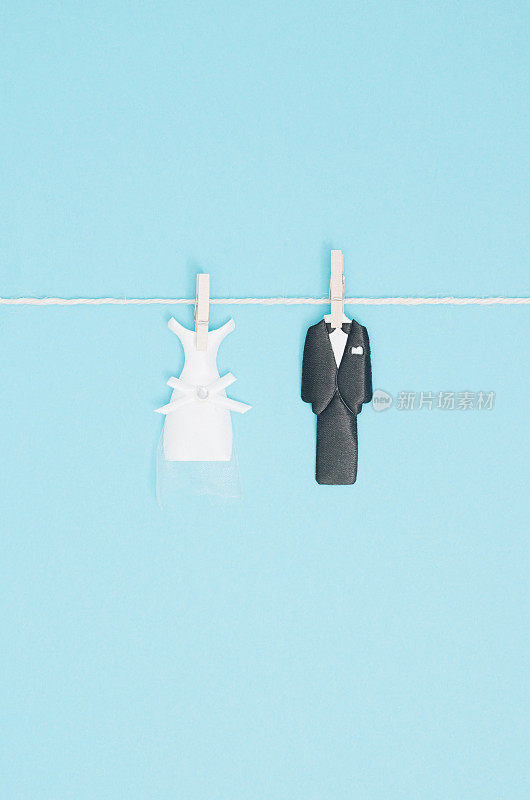 新娘和新郎用一根线用木衣夹夹住。婚礼邀请卡。最少,平。