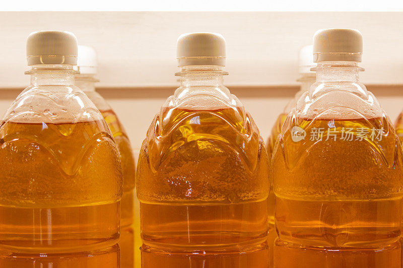 柜台上有装啤酒或蜂蜜酒的塑料瓶。一瓶瓶的植物油特写。