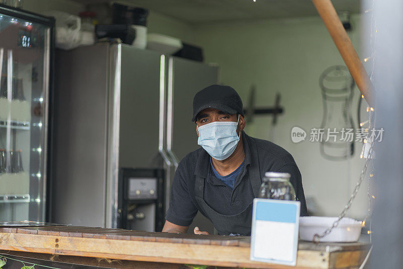 餐车服务员穿着他的牌子在店里看着镜头