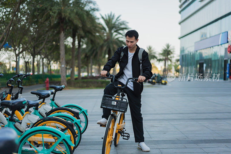 一名亚洲男子准备乘坐共享自行车旅行