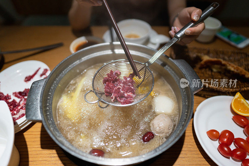 亚洲妇女用筷子夹牛肉