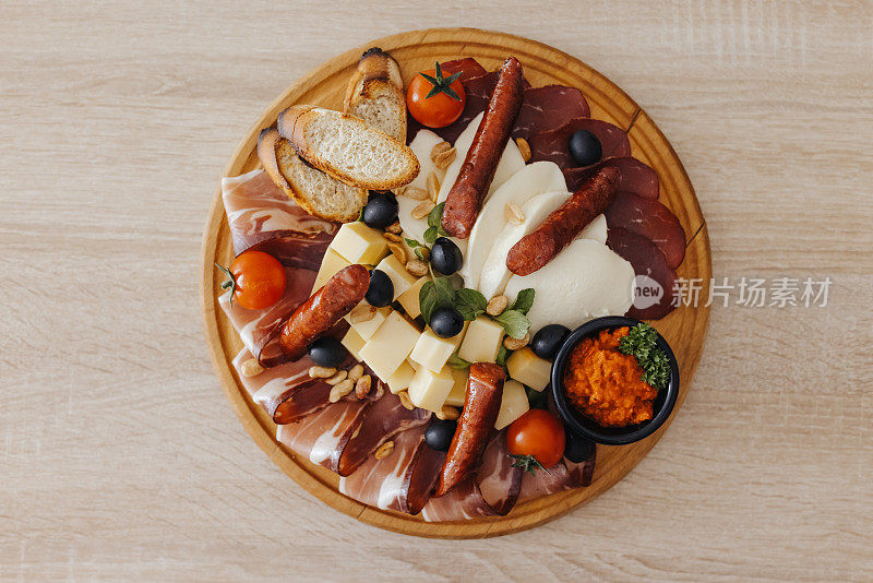 各种美味的肉片和不同的奶酪放在木板上