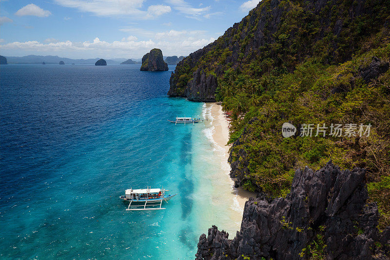 天堂般的海滩，碧蓝的海水，一对夫妇在菲律宾的一个岛上独自享受