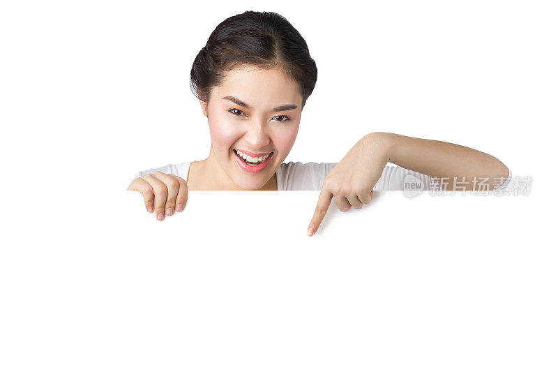 年轻的亚洲女人展示和指着空白的广告牌