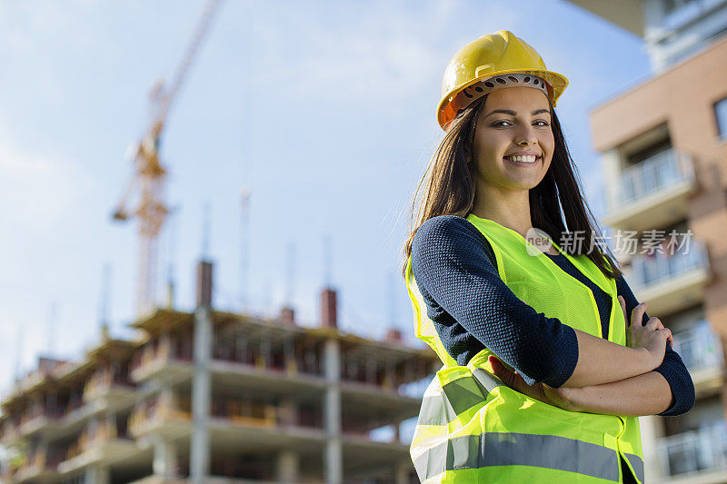 年轻的女工程师在建筑工地微笑