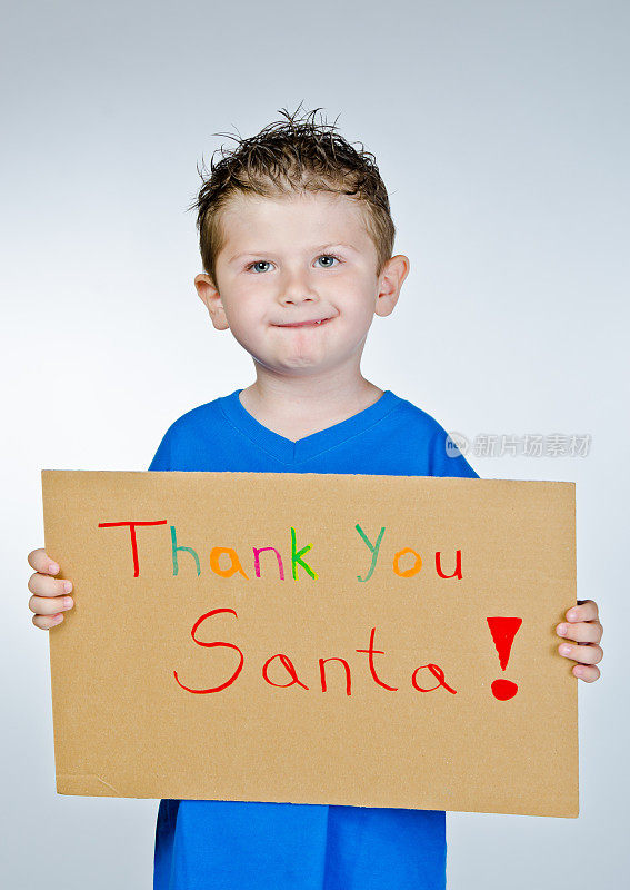 小男孩拿着感谢圣诞老人的标志