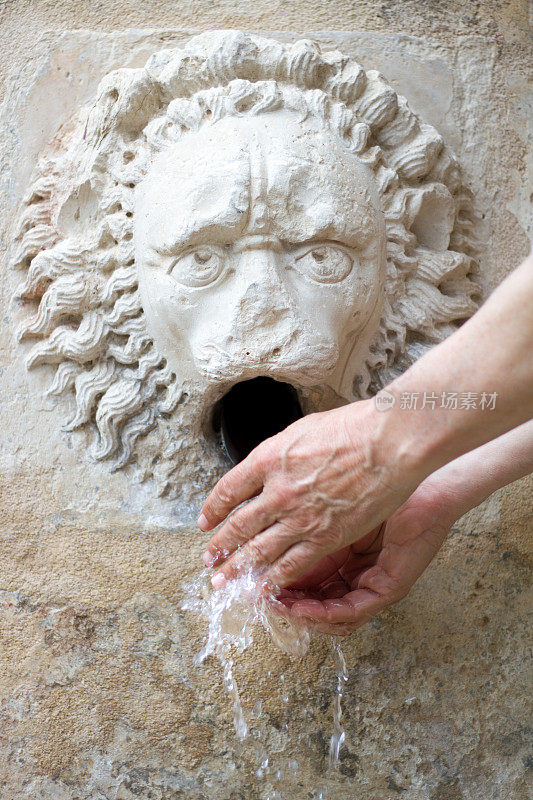 西西里岛，一名男子在古石狮喷泉洗手