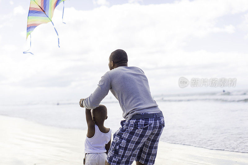 非洲父子在海滩上放风筝